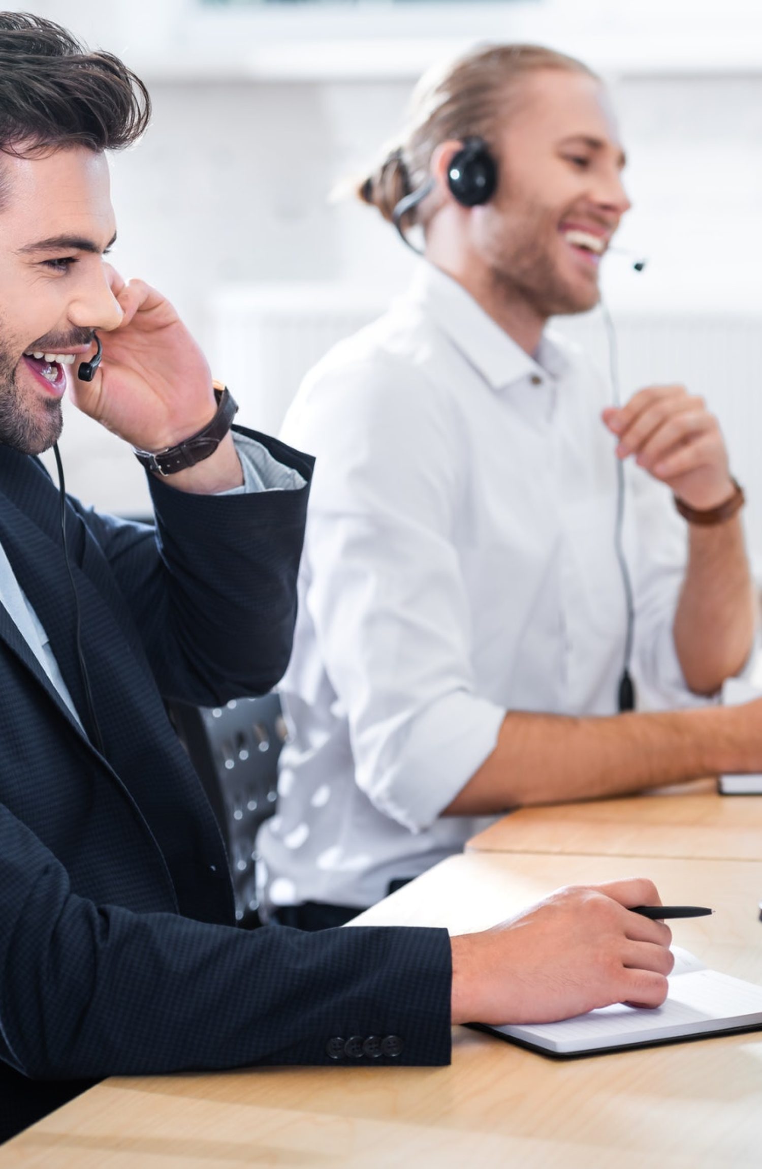 side-view-of-male-call-center-operators-in-headsets-at-workplace-in-office.jpg